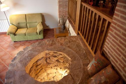 a living room with a couch and a stone fireplace at Casa Abuelina in Titaguas