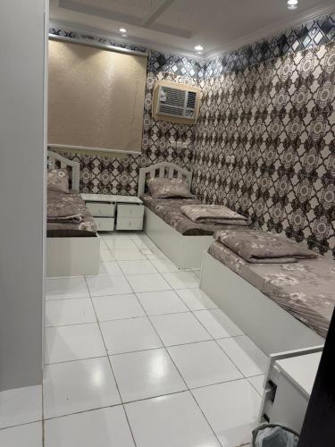 a room with two beds on a tiled floor at رفاه الماسي in Medina