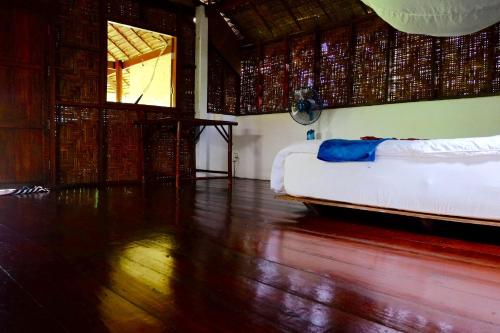 a room with a bed and a wooden floor at Andaman Sunflower in Ko Lanta