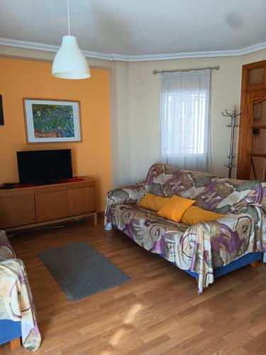 a living room with a couch and a flat screen tv at Casa Alice in La Nucía