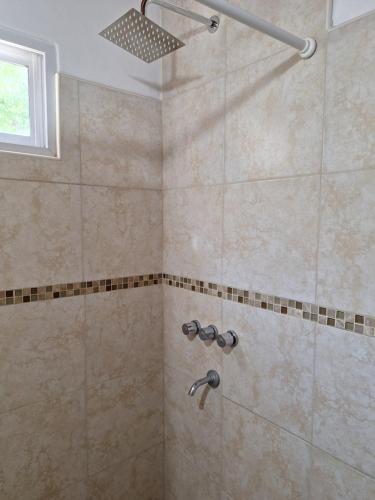 a bathroom with a shower with a shower head at Cabañas Tinku del Sol in Casa Grande