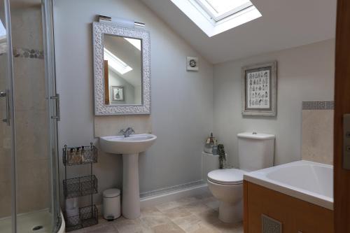 a bathroom with a sink toilet and a mirror at Harbour View Penthouse in Lowestoft