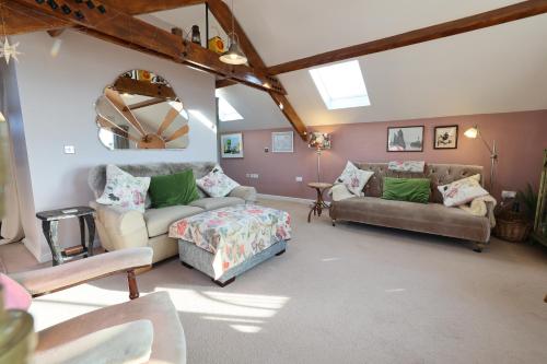a living room with two couches and a table at Harbour View Penthouse in Lowestoft