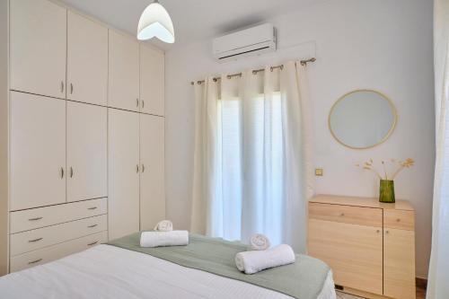 a bedroom with white cabinets and a bed with two towels at Casa Di Kontini in Acharavi