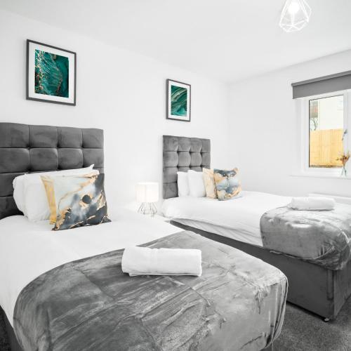 two beds in a room with white walls at Stylish Two Bed Apartment - Parking - Sleeps 3 - Netflix 55C in Sleightholme