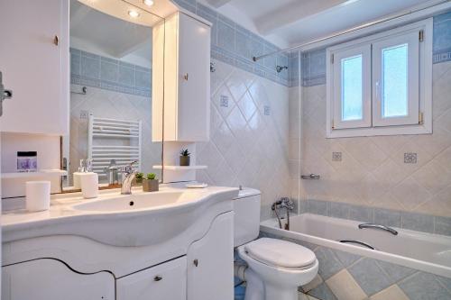 a bathroom with a sink and a toilet and a tub at Casa Di Kontini in Acharavi