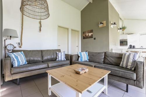 a living room with a couch and a table at Rekerlande 274 in Warmenhuizen