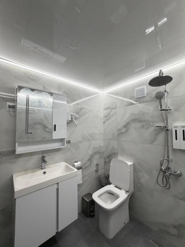 a white bathroom with a toilet and a sink at ValMar Guest rooms in Haskovo