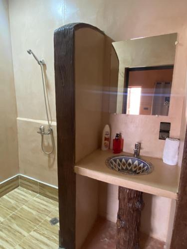 a bathroom with a sink and a mirror and a shower at Palais Ksar Lamane in Aït Benhaddou