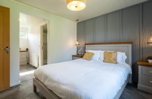 a bedroom with a large bed with white sheets at Landal Aysgarth in Aysgarth
