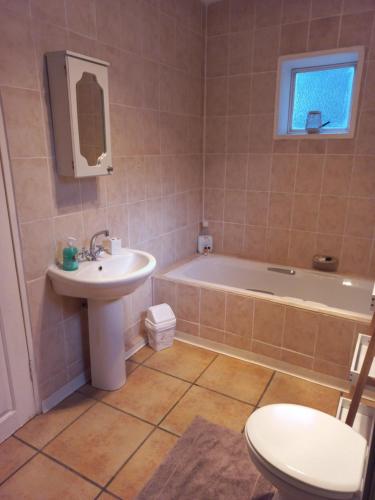a bathroom with a tub and a sink and a toilet at Forever Clarens in Clarens