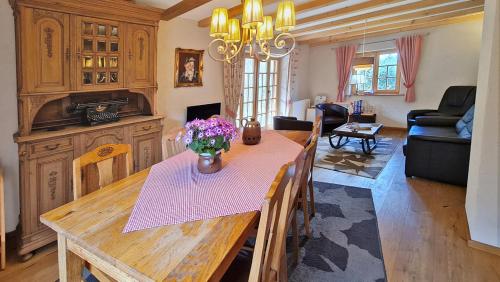 a dining room with a table with flowers on it at Kienberghäusle in Pfronten