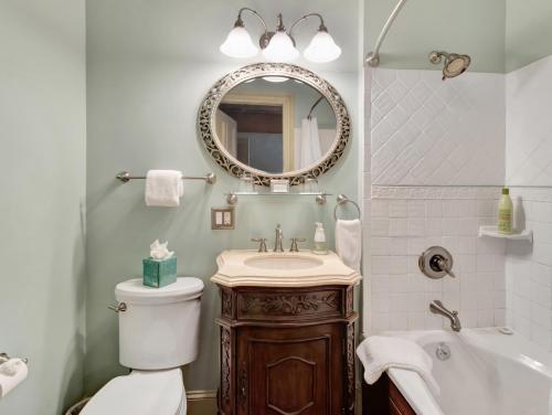 a bathroom with a toilet and a sink and a mirror at Proctor Mansion Inn in Wrentham