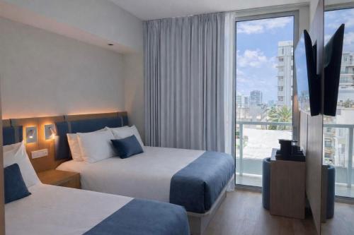 a hotel room with two beds and a large window at Dolce by Wyndham Miami Beach in Miami Beach