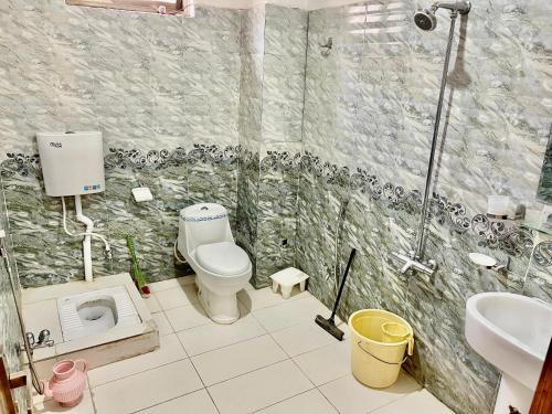 a bathroom with a toilet and a sink and a shower at Cecil homes hotel in Murree