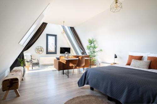 a bedroom with a bed and a table and chairs at Yn 'e Haven Logies in Earnewâld