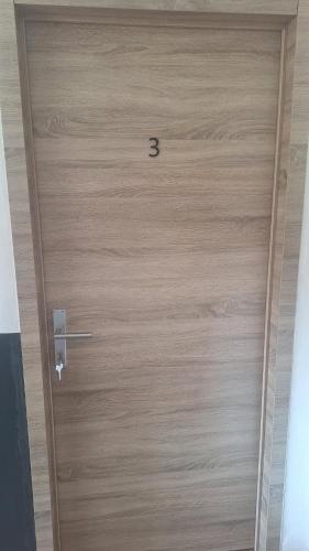 a wooden door with the number three on it at Residence La Fafa in Charleroi