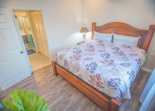 a bedroom with a bed with a floral bedspread at Executive 1BR Downtown POS with ensuite bath in Port-of-Spain