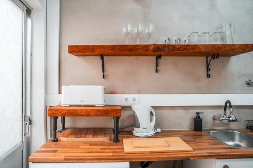 a kitchen with wooden shelves and a sink at Blue Bay in Lagos