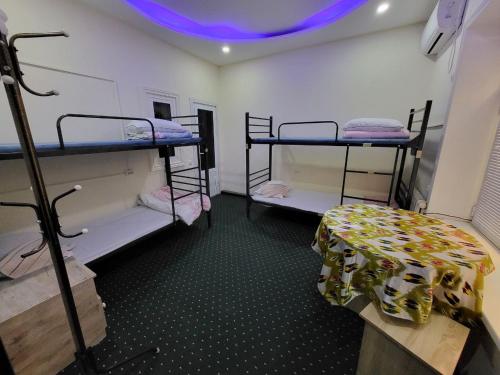 a room with three bunk beds and a purple light at Bobo Haydar FREE LONDRY SERVICE in Bukhara