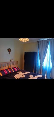 a bedroom with a bed and a blue curtain at Entire flat with 2 separate rooms in Norwood
