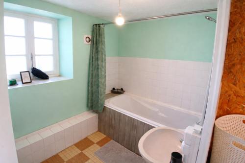 a bathroom with a tub and a sink at location Vakañsoù in Lanouée