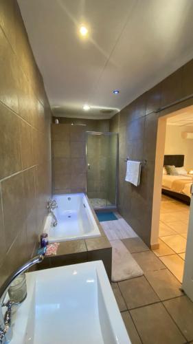 a large bathroom with a tub and a shower at The Oasis Guesthouse in Mtubatuba