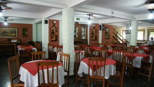 a dining room with red and white tables and chairs at Pousada Fazenda Buracão in Mococa