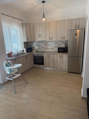 a kitchen with wooden cabinets and a stainless steel refrigerator at Castle view 2 in Kavála