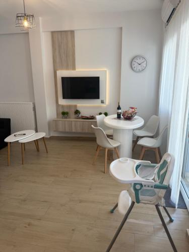 a living room with a tv and a table and chairs at Castle view 2 in Kavála