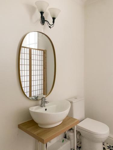 a bathroom with a sink and a mirror and a toilet at Cozy en suite room in King's Lynn