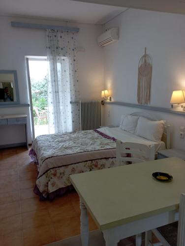 a hotel room with two beds and a table at Paradisos Studios in Pyrgi Thermis