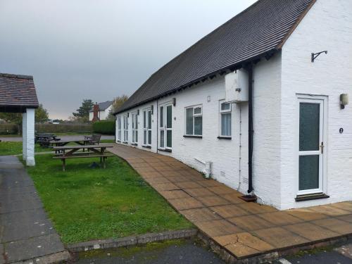 a white building with a picnic table next to it at The Green Dragon Inn in Redditch