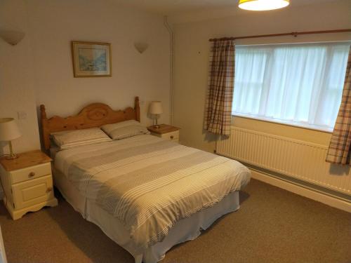 a bedroom with a large bed and a window at The Green Dragon Inn in Redditch