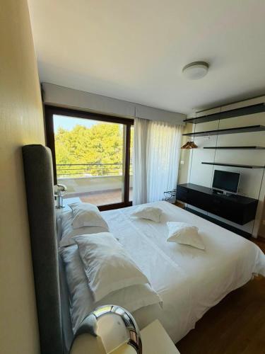 a bedroom with a large white bed with a window at Darkin 10 in Strožanac