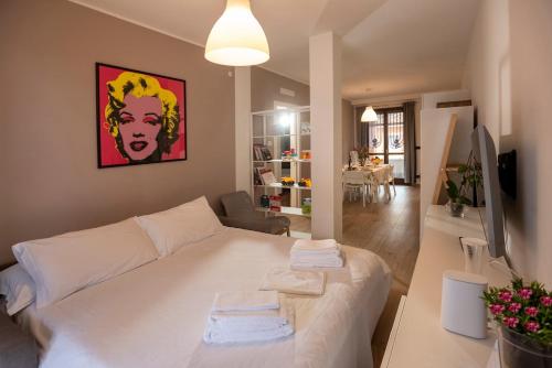 a bedroom with a white bed and a living room at Casa Valentin in Monforte dʼAlba