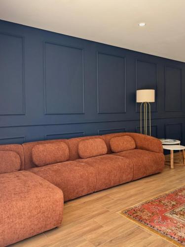 a couch in a living room with a blue wall at Villa Rosa in Melgaço