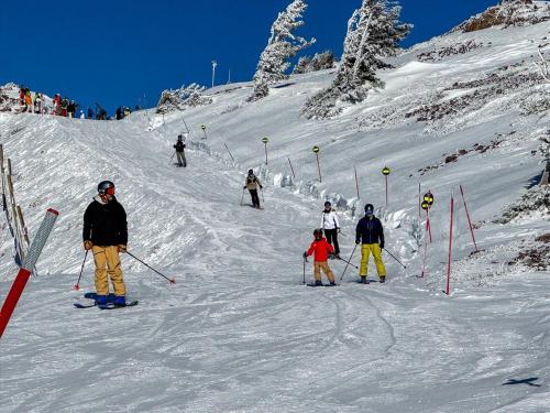a group of people skiing down a snow covered slope at Powder Mtn Trapper Lodge TR1 Ski Retreat Game Rm in Eden