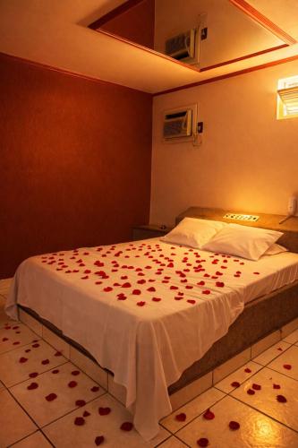 a bedroom with a bed with red roses on it at Classik Prime Motel in Araçatuba