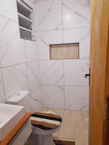 a bathroom with a toilet and a sink at Duplex 2 quartos pertinho da Praia in Tramandaí