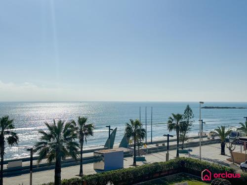 a view of a beach with palm trees and the ocean at Poble Mar 7 in Oropesa del Mar