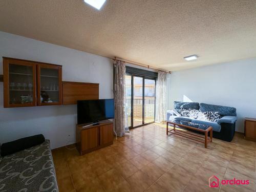a living room with a couch and a tv at Poble Mar 7 in Oropesa del Mar