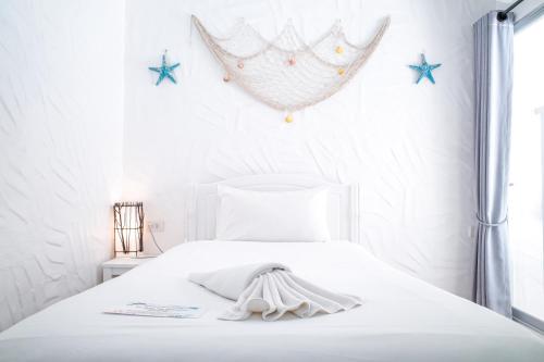 a white bedroom with a bed with stars on the wall at Phi Phi Indigo Hotel in Phi Phi Islands