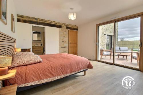 a bedroom with a large bed and a balcony at La casa de silz in Arzal