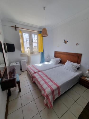 a bedroom with a bed and a television in it at Maria Guest house in Albufeira