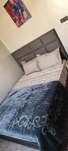 a bedroom with a large bed with a blue blanket at Tata hôte in Tatta