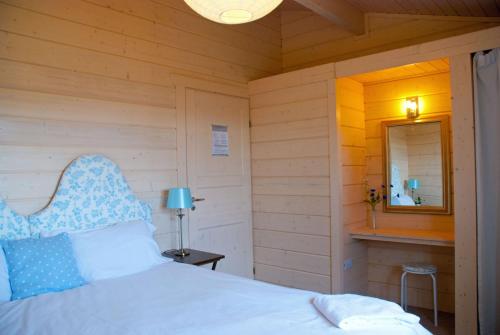 a bedroom with a white bed and a mirror at Lapwing Lodge in Dumfries