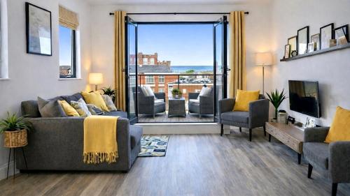 a living room with a couch and chairs and a tv at Margate Penthouse Private Balconies Sea Glimpses Gated Parking Air-Con The Penthouse Margate in Margate