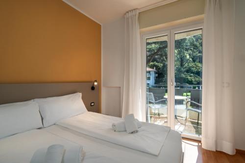 a bedroom with a bed and a large window at Ventus Park Hotel in Nago-Torbole