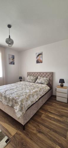 a bedroom with a large bed and wooden floors at Apartman Ivan Trebinje in Trebinje